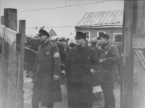 Three Jewish ghetto officials stand at one of the gates to the Kovno ghetto